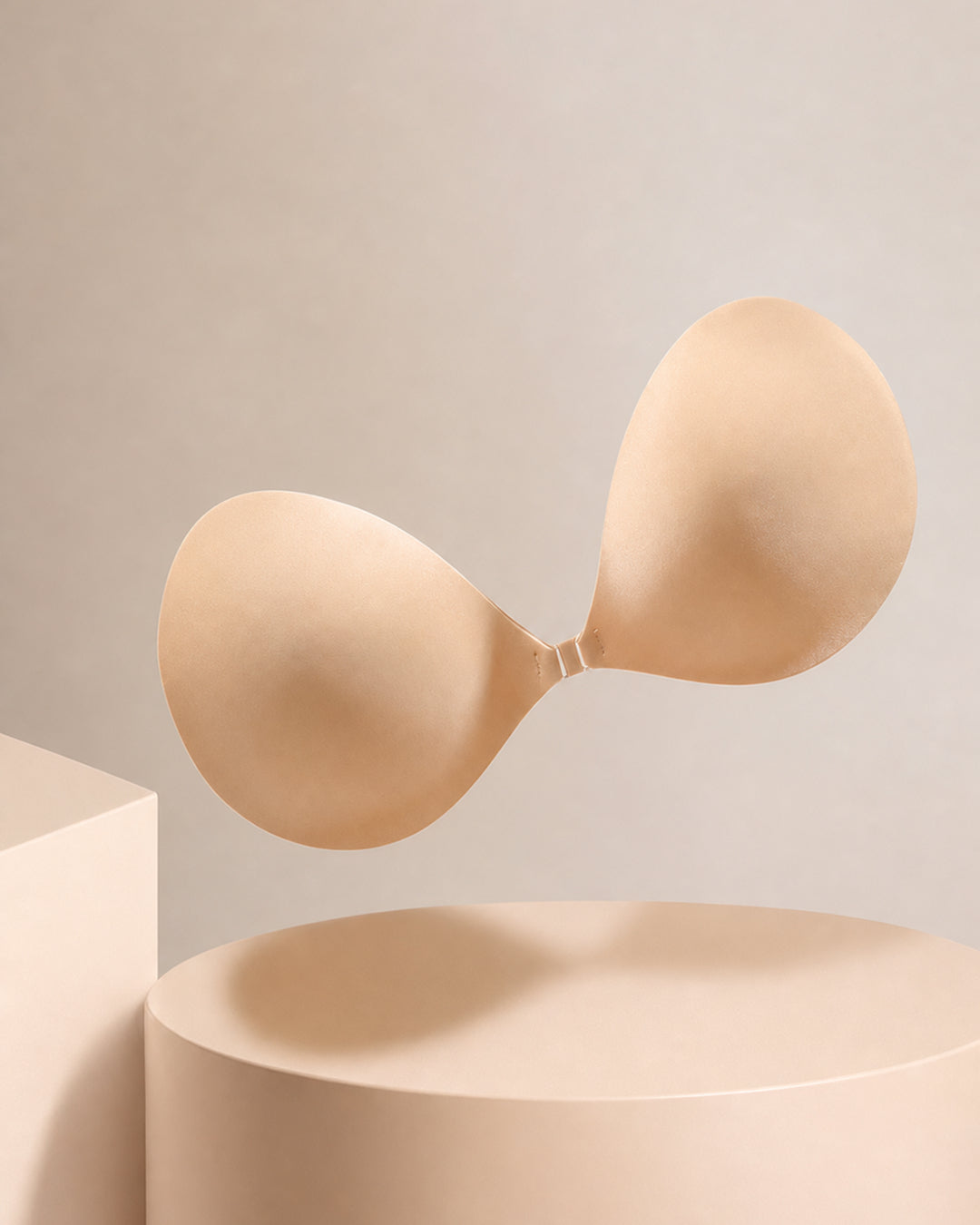 The strapless adhesive bra from the side on a plinth, showing cup depth