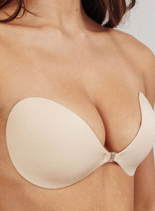 Close-up of the nude adhesive bra on the body, showing the front clasp and lift