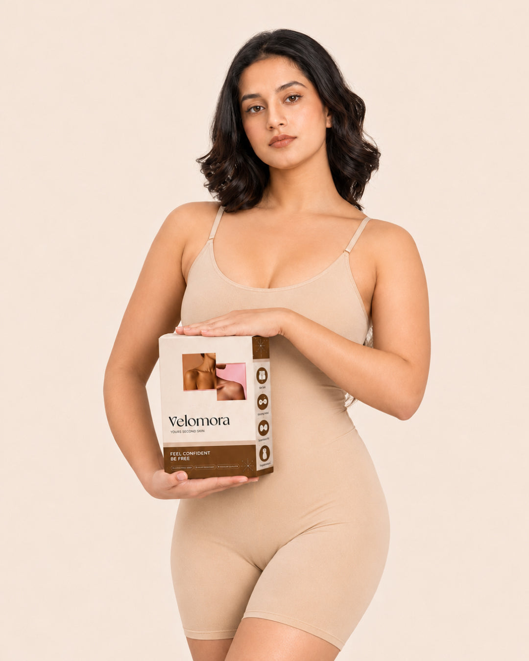 Model holding the bodysuit in its packaging box